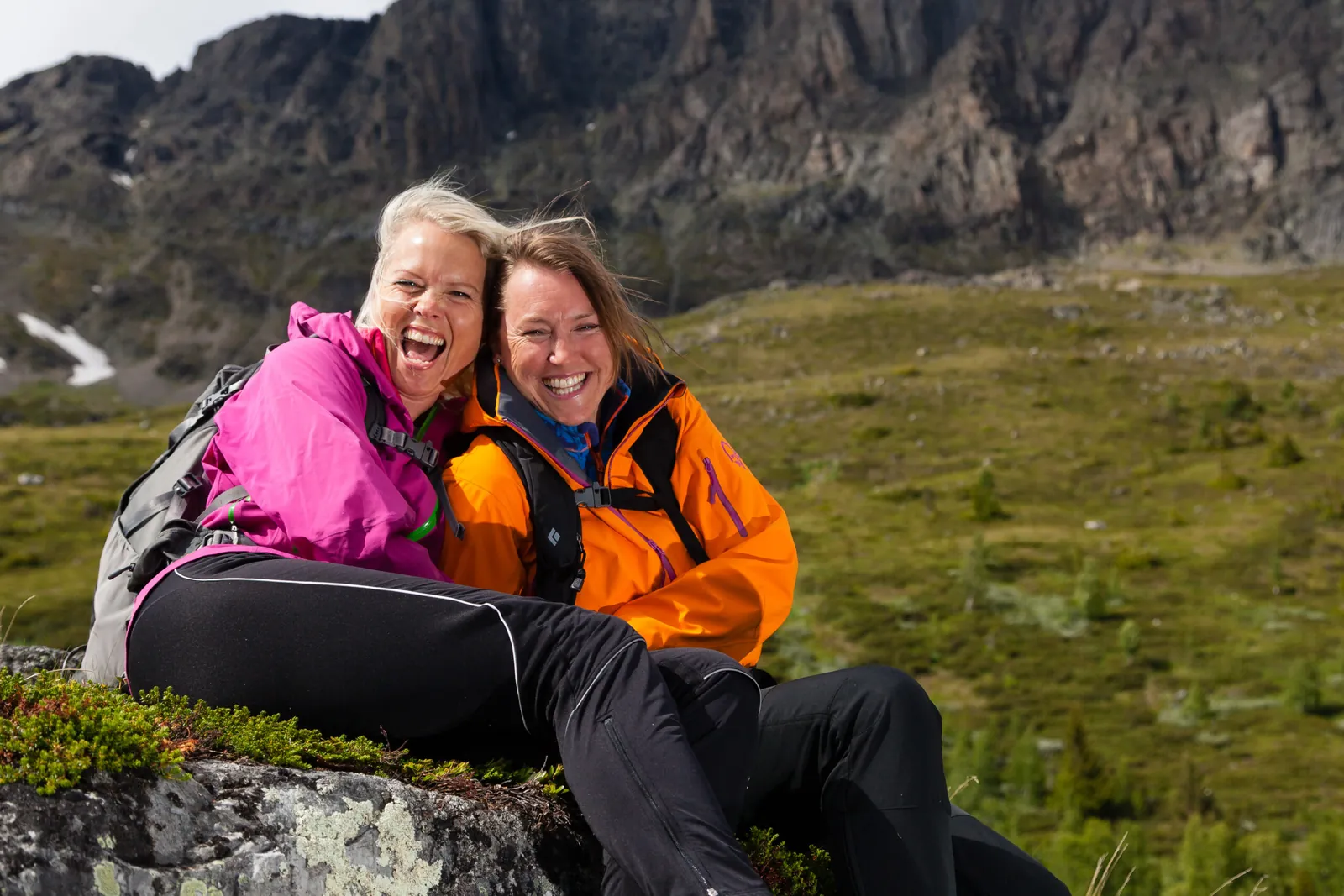 To smilende kvinner på fjelltur i norske fjell